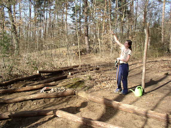 Eine junge Frau bei der Arbeit an einem Barfußpfad im Wald